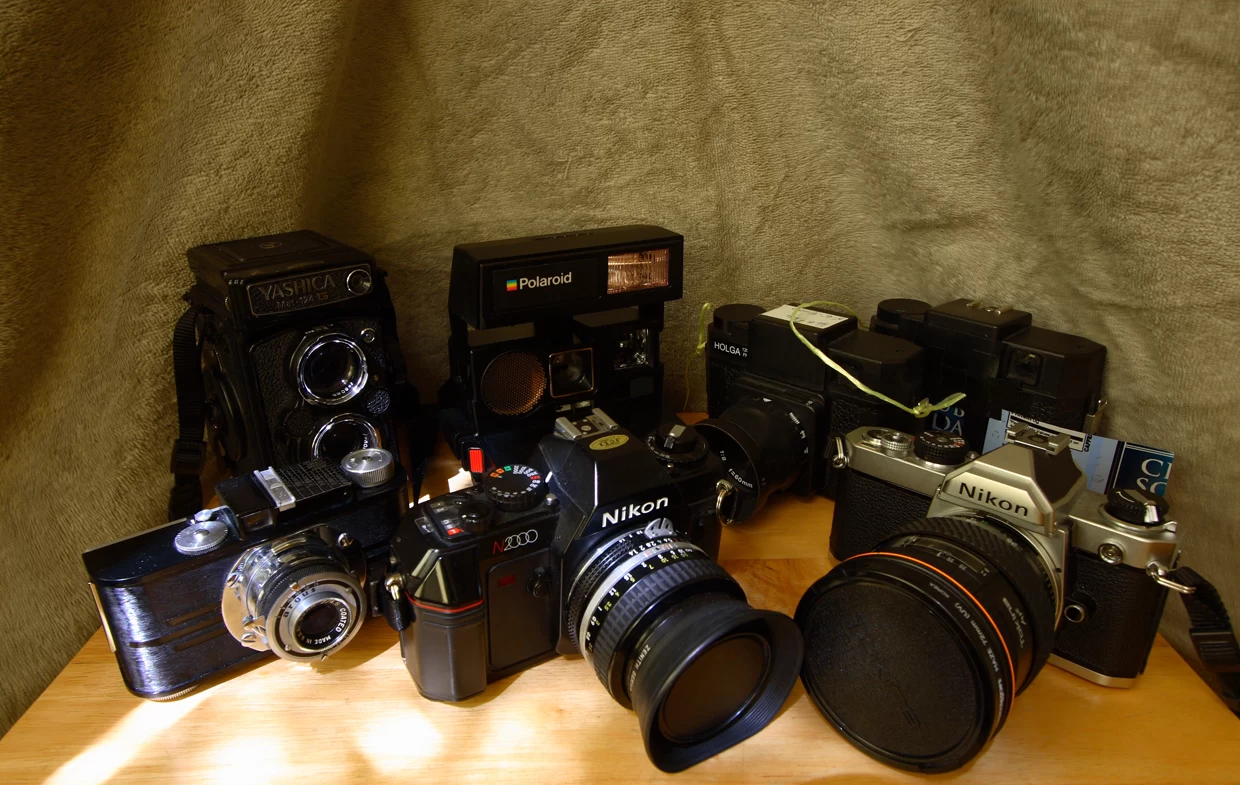 Coleção de câmeras fotográficas analógicas de diferentes formatos e fabricantes.